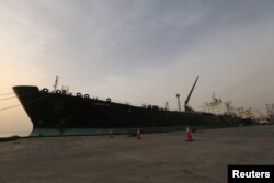 FILE - A cargo ship unloads a shipment of fuel at the Hudeida port, Yemen, May 27, 2018.