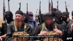FILE - An image made available by jihadist media outlet al-Itisam Media on June 29, 2014, allegedly shows members of the Islamic State, including ethnic Chechen Abu Omar al-Shishani (Tarkhan Batirashvili), pictured center-left with red beard.
