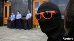 An activist takes part in a protest calling for an end to the ceasefire against separatist rebels outside the Presidential Administration Building in Kyiv, June 28, 2014. 