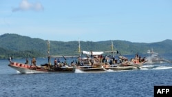 Philippine fishermen sail along Ulugan Bay south of Manila before heading to the open sea facing south China sea to fish.
