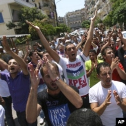 Protesters shout slogans as they gesture during a protest organised by Lebanese and Syrians living in Lebanon, to express solidarity with Syria's anti-government protesters, as they march in Tripoli, northern Lebanon, July 15, 2011. REUTERS/Omar Ibrahim (