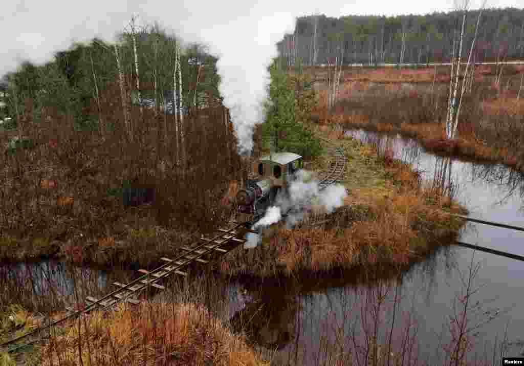 A homemade steam train, designed by Pavel Chilin, travels on a makeshift railway through neighborhood of country houses in the settlement of Ulyanovka in the Leningrad region of Russia, Nov. 4, 2019.