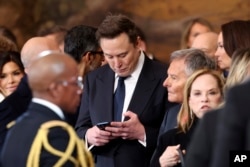 Elon Musk menggunakan telepon selulernya setelah Pelantikan Presiden ke-60 di Rotunda Gedung Capitol AS di Washington, Senin, 20 Januari 2025. (Kevin Lamarque via AP)