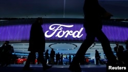 FILE - Attendees walk by the Ford display at the North American International Auto Show in Detroit, Jan. 11, 2016. 