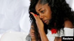 Myeshia Johnson, widow of U.S. Army Sergeant La David Johnson, who was among four special forces soldiers killed in Niger, sits with her daughter, Ah'Leeysa Johnson at a graveside service in Hollywood, Florida, Oct. 21, 2017. 