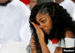Myeshia Johnson, widow of U.S. Army Sergeant La David Johnson, who was among four special forces soldiers killed in Niger, sits with her daughter, Ah'Leeysa Johnson at a graveside service in Hollywood, Florida, Oct. 21, 2017.