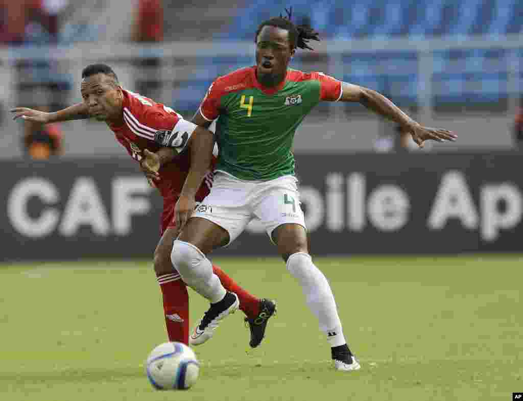 Bakary Koné du Burkina Faso, à droite, aux prises avec Emilio Nsue de la la Guinée équatoriale, à gauche, lors de la rencontre Burkina Faso-Guinée équatoriale de la Coupe d&#39;Afrique des Nations Groupe A à Bata, en Guinée équatoriale, mercredi 21 janvier 2015.