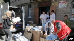 FILE - Volunteers and doctors unload a car with medical supplies from a volunteer organization to the army, at a hospital in Artemovsk, Donetsk region, Ukraine, Sept. 18, 2014.