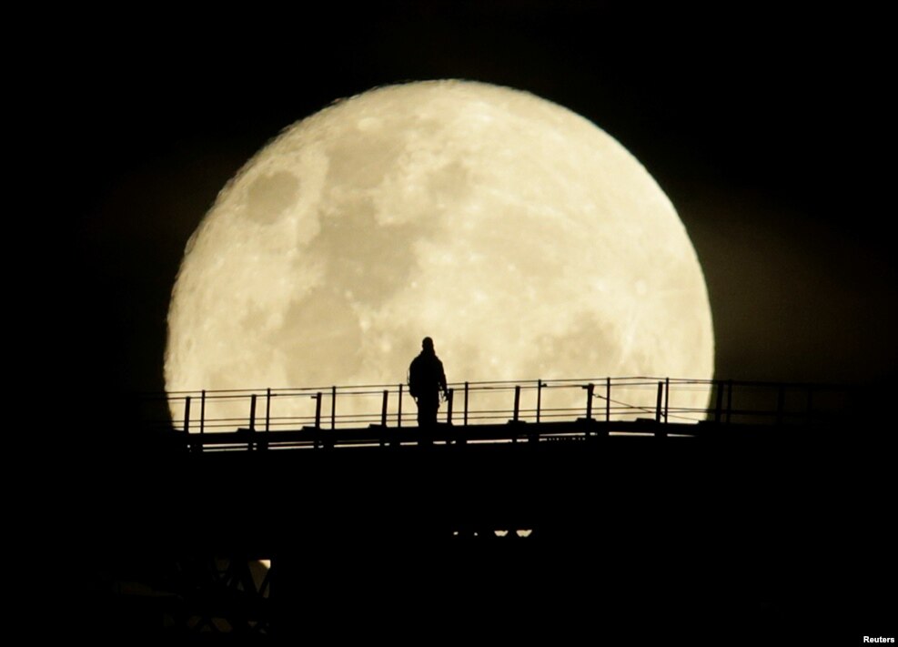 A man walks on the top span of the Sydney Harbour Bridge as the supermoon enters its final phase in Sydney, Australia, Nov. 15, 2016.