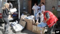 FILE - Volunteers and doctors unload a car with medical supplies from a volunteer organization to the army, at a hospital in Artemovsk, Donetsk region, Ukraine, Sept. 18, 2014.