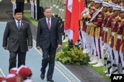 Presiden Indonesia Prabowo Subianto (kiri) dan Sekretaris Jenderal Partai Komunis Vietnam To Lam (tengah) memeriksa barisan kehormatan Presiden di Istana Kepresidenan di Jakarta,10 Maret 2025. (BAY ISMOYO / AFP)