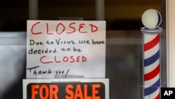 "For Sale By Owner" and "Closed Due to Virus" signs are displayed in the window of Images On Mack in Grosse Pointe Woods, Mich., April 2, 2020.