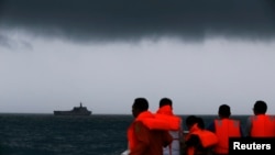 Rescue team members look out toward the ship KRI Banda Aceh as dark clouds fill the sky during a search operation for passengers onboard AirAsia Flight 8501 in the Java Sea, Jan. 4, 2015. 