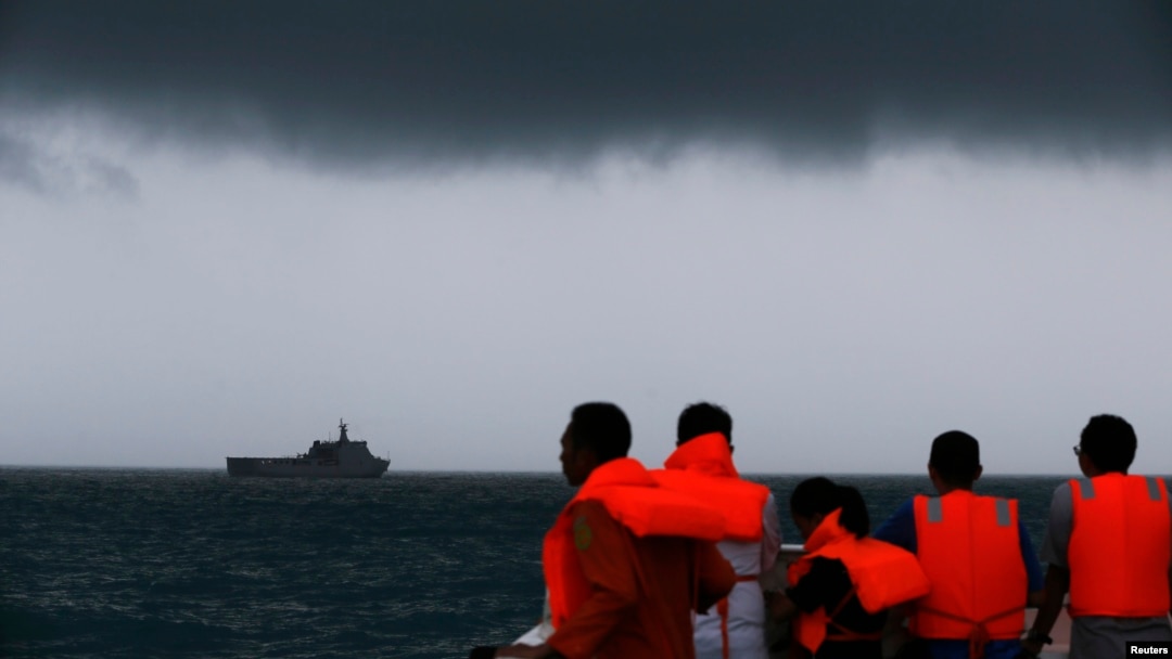 Anggota Tim SAR melihat ke arah kapal KRI Banda Aceh semantara awan gelap menggantung di langit selama operasi pencarian korban kecelakaan pesawat AirAsia 8501 di Laut Jawa (4/1).