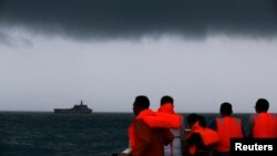 Anggota Tim SAR melihat ke arah kapal KRI Banda Aceh semantara awan gelap menggantung di langit selama operasi pencarian korban kecelakaan pesawat AirAsia 8501 di Laut Jawa (4/1).