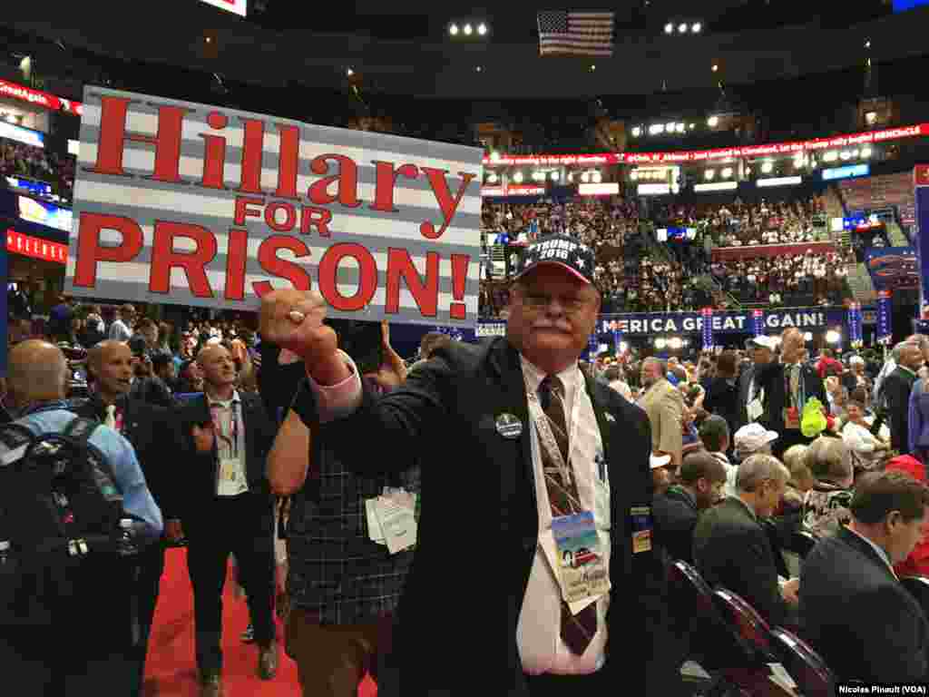 Un participant brandit une pancarte &quot;Hillary en prison !&quot;, à l&#39;ouverture de la convention nationale des républicains à Cleveland, Ohio, le 18 juillet 2016. (VOA/Nicolas Pinault)