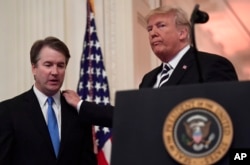 President Donald Trump, right, stands with Supreme Court Justice Brett Kavanaugh, left, before a ceremonial swearing in in the East Room of the White House in Washington, Monday, Oct. 8, 2018.