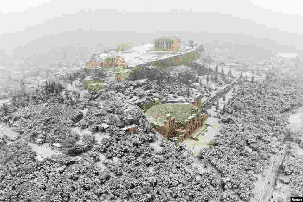 The Parthenon temple is seen atop the Acropolis hill during heavy snowfall in Athens, Greece.