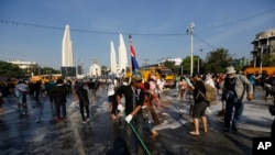 Anti-government protesters sweep streets in front of the Democracy Monument in Bangkok, Thailand, Wednesday, Dec. 4, 2013.
