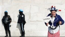 Seorang pria mengenakan kostum berpose di samping polisi di Lincoln Memorial dalam aksi unjuk rasa menentang mandat vaksin di Washington, D.C., pada 23 Januari 2022. (Foto: Reuters/Tom Brenner)