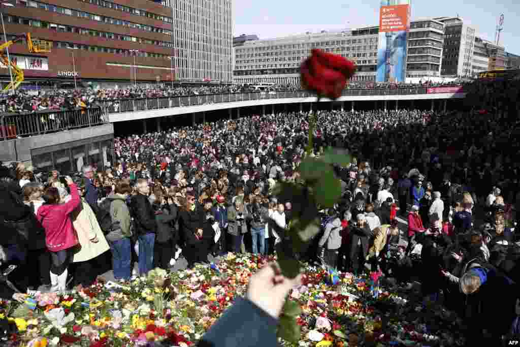 스웨덴 스톡홀름 시민들이 며칠전 트럭 돌진 사건으로 4명이 숨지고 15명이 부상당한 올렌스 백화점 인근에서 추모행사를 열고 있다. 당국은 이 사건을 테러로 규정하고, 검거한 용의자들을 대상으로 조사를 벌이고 있다. &nbsp;