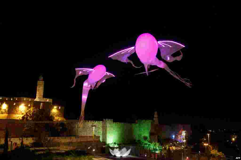 Two light installations shaped as fish hoover over Jerusalem&#39;s old city ancient walls during the Jerusalem Festival of Lights, June 4, 2013.