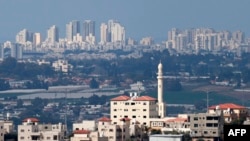 This picture shows a partial view of Tulkarem in the occupied-West Bank with the Israeli city of Netanya in the background on Feb. 21, 2025. 
