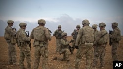 FILE - U.S. soldiers gather for a brief during a combined joint patrol rehearsal in Manbij, Syria. 