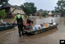 Brad and Bart Hindley take a boat to Brad's flooded house in Fort Smith, Ark., May 29, 2019. Brad said he doesn't live in a flood plain, but flood waters from the Arkansas River continue to rise.