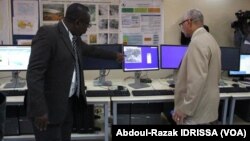 Des membres de la réunions regardent le matériel utilisé pour mener les recherches (Abdoul-Razak Idrissa / VOA).