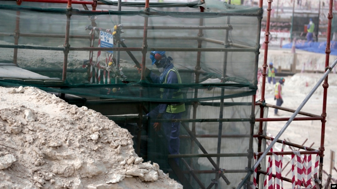 Seorang pekerja asing memanjat perancah di Stadion Al-Wakra, Doha, Qatar, yang sedang dibangun untuk penyelenggaraan Piala Dunia 2022. (Foto: dok). Qatar telah menghapus persyaratan visa keluar (exit visa) bagi semua pekerja migran. 