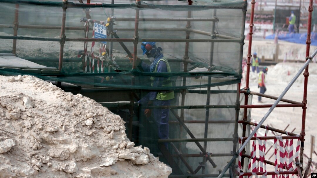 In this photo taken during a government organized media tour, a foreign worker climbs scaffolding at the Al-Wakra Stadium that is under construction for the 2022 World Cup, in Doha, Qatar, May 4, 2015.