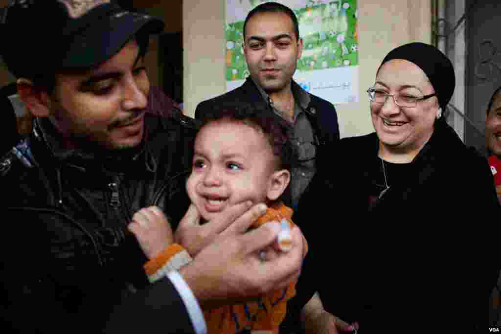 Egyptian Health Minister Maha el Rabat looks on as a child is immunized against polio in Cairo, Nov. 17, 2013. (Yuli Weeks for VOA)