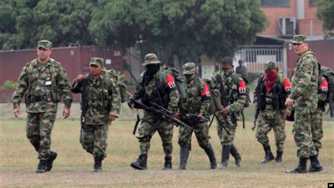 Tentara Kolombia (kanan dan kiri) mengawal para pemberontak dari Laskar Pembebasan Nasional (ELN) saat menyerahkan diri di basis militer di Cali, Kolombia, 16 Juli 2013 (Foto: dok).