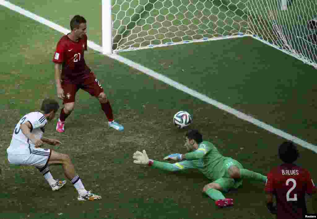 Germany&#39;s Thomas Mueller (L) shoots to score against Portugal for his hat-trick during their 2014 World Cup Group G soccer match at the Fonte Nova arena in Salvador, June 16, 2014.&nbsp;