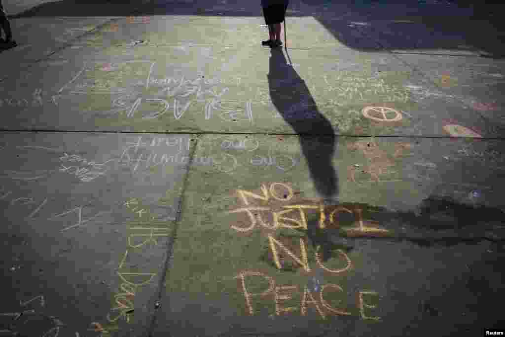 Messages written in a parking lot protest the shooting of Michael Brown in Ferguson, Missouri, Aug. 15, 2014.