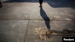 Messages written in a parking lot protest the police shooting of Michael Brown in Ferguson, Missouri, on Aug. 15, 2014. 