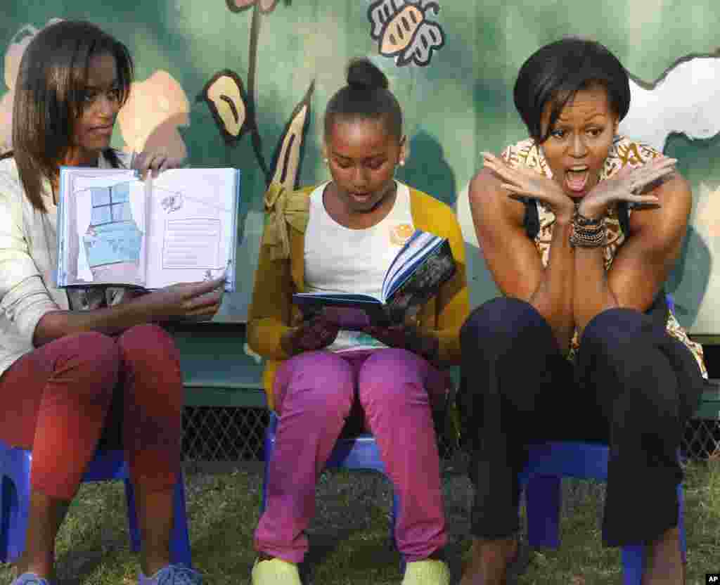 Michelle Obama e as filhas Sasha (centro) e Malia, leram o conto infantil americano "O Gato no Chapéu " a um grupo de crianças sul-africanas.
