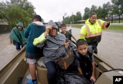 Evacuees ride in a boat down Tidwell Road as floodwaters from Tropical Storm Harvey rise in Houston, Aug. 28, 2017.