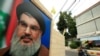 Seorang pengendara motor tampak melewati gambar dari pemimpin Hizbullah Lebanon Sayyed Hassan Nasrallah yang terpampang di jalan dekat Sidon. (Foto: Thomson Reuters)