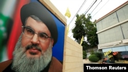 Seorang pengendara motor tampak melewati gambar dari pemimpin Hizbullah Lebanon Sayyed Hassan Nasrallah yang terpampang di jalan dekat Sidon. (Foto: Thomson Reuters)