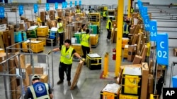 Співробітники Amazon завантажують пакунки, щоб відправити їх вантажівками в рамках щорічного заходу Amazon Prime Day, Саут-Гейт, штат Каліфорнія (AP Photo/Richard Vogel, File).