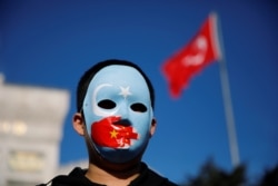 Seorang bocah etnis Uighur mengenakan topeng saat protes terhadap China di Istanbul, Turki, 14 Desember 2019. (Foto: Reuters)