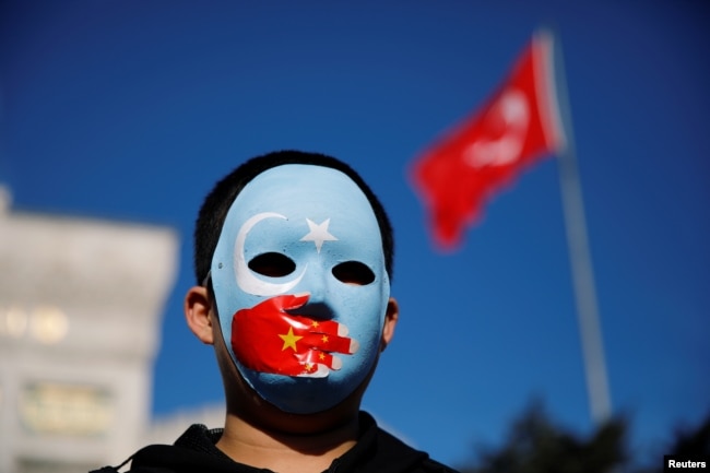 Seorang bocah etnis Uighur mengenakan topeng saat protes terhadap China di Istanbul, Turki, 14 Desember 2019. (Foto: Reuters)