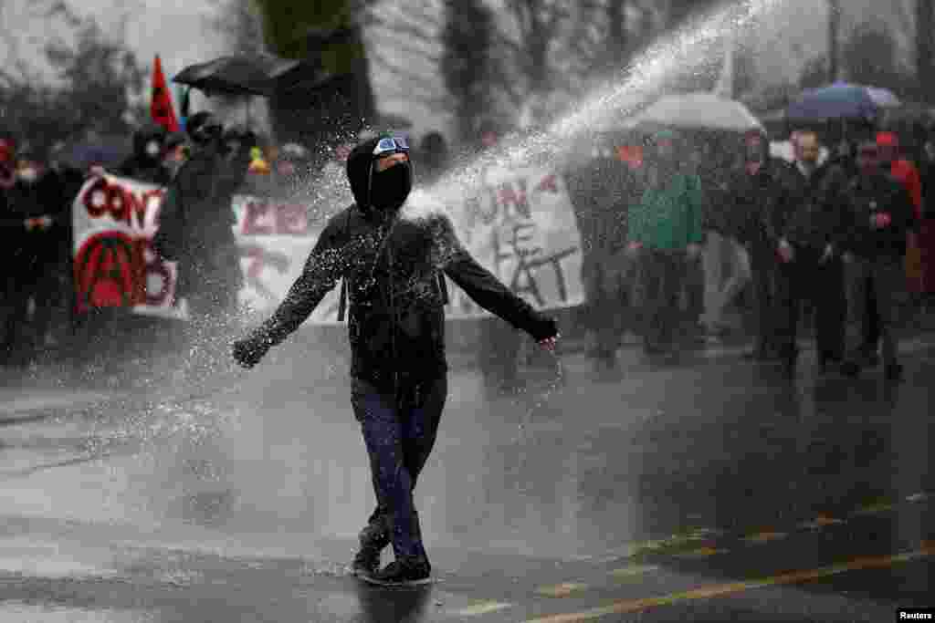 A demonstrator faces off with armed French police officers during a demonstration by labor union members and workers on strike in Nantes, during the 36th straight day of strikes against the government&#39;s retirement reform plans.