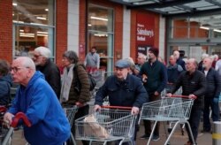 FILE - Elderly people wait for a Sainsburys supermarket to open as the spread of the coronavirus disease (COVID-19) continues, in Hertford, Britain, March 19, 2020.