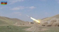 A still image from a video released by Azerbaijan's Defense Ministry shows a multiple rocket launcher of the Azeri armed forces performing strikes during clashes over the breakaway region of Nagorno-Karabakh in Azerbaijan, Sept. 30, 2020.