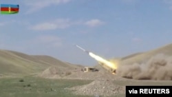 A still image from a video released by Azerbaijan's Defence Ministry shows a multiple rocket launcher of the Azeri armed forces performing strikes during clashes over the breakaway region of Nagorno-Karabakh in Azerbaijan, Sept. 30, 2020.