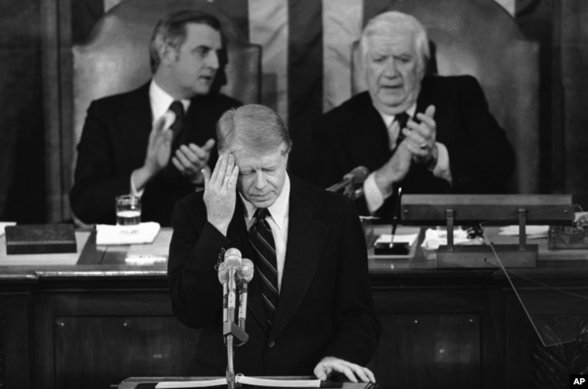 FILE - President Jimmy Carter touches his brow as he addresses those in the House chamber of the Capitol in Washington on Jan. 23, 1979. (AP Photo)