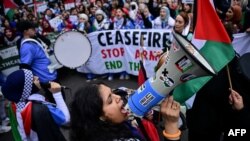 FILE - A Pro-Palestinian supporter chants slogans in a loudspeaker as she takes part in a National March for Palestine in central London on February 3, 2024.